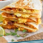 Pinterest graphic of breakfast quesadilla recipe. Image is overhead photo of breakfast quesadilla. Bowl of pico de gallo on the side for garnish. Text says, "Breakfast quesadilla simplejoy.com"