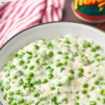 Pinterest graphic of creamed peas recipe. Text says, "Better than grandma's creamed peas. simplejoy.com" Overhead photo of creamed peas in a bowl.