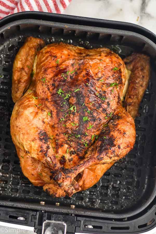 Overhead photo of air fryer whole chicken in air fryer basket.