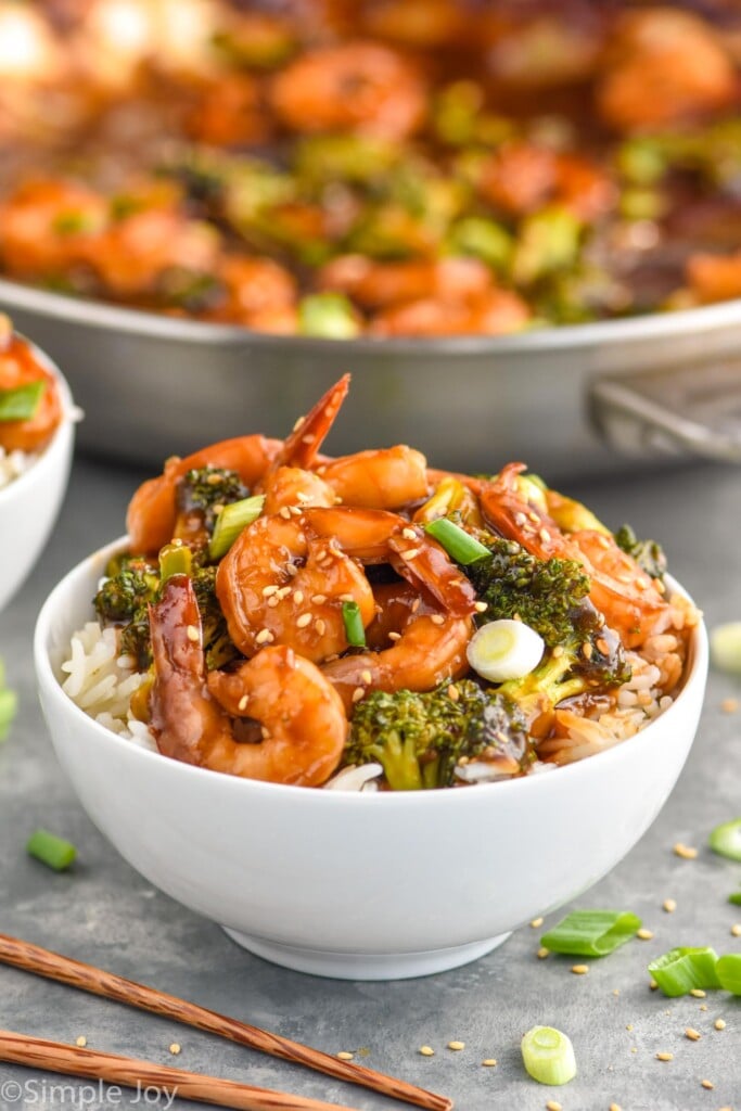 Overhead photo of shrimp and broccoli stir fry served in a white bowl over white rice.