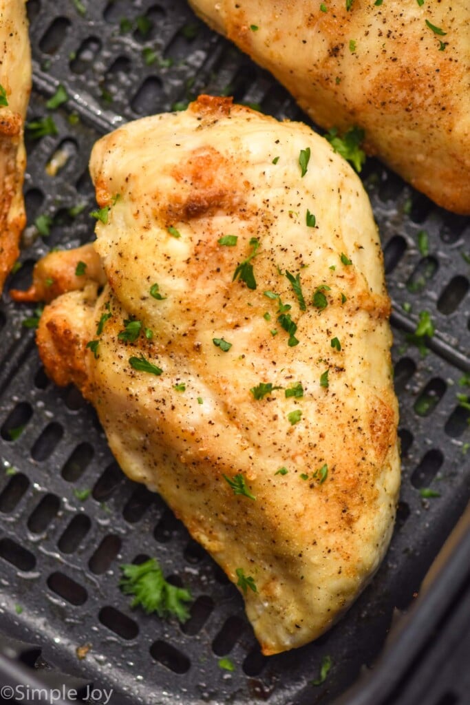 Overhead photo of air fryer chicken breasts in air fryer basket