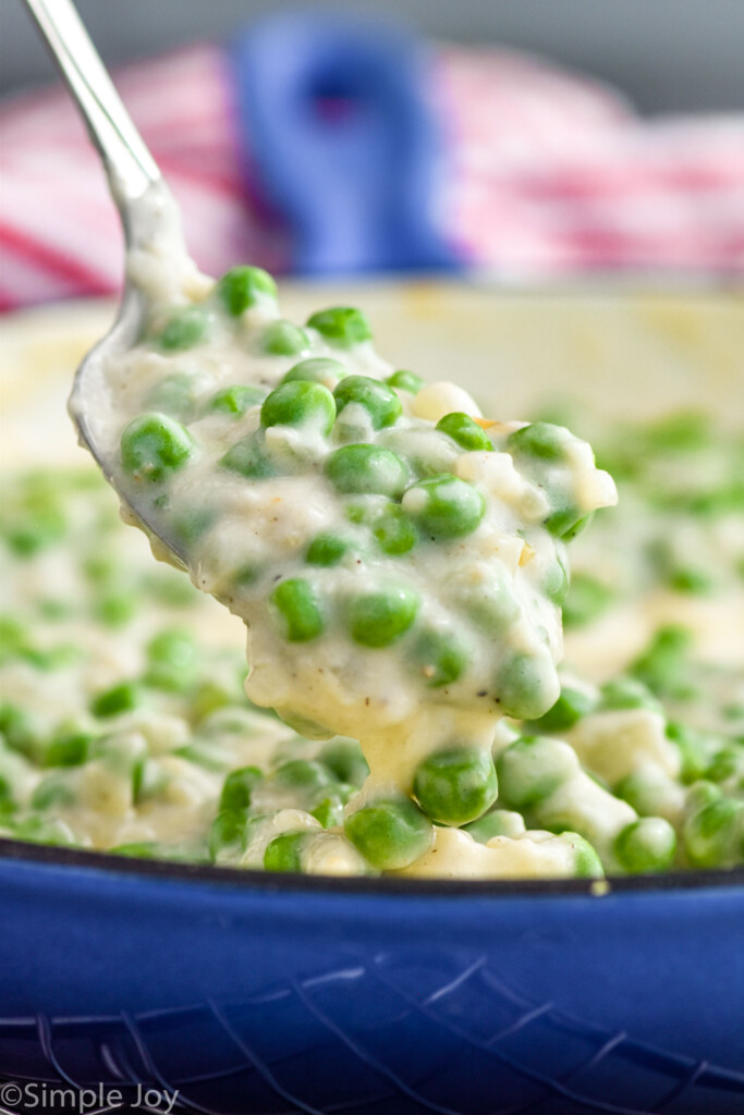 Photo of spoon scooping creamed peas out of bowl.