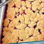 Pinterest graphic of blackberry cobbler. Overhead photo of a plan of blackberry cobbler with a spoon scooping some out. Text says, "blackberry cobbler simplejoy.com"
