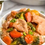 Pinterest graphic of pork stir fry. Text says, "the best pork stir fry simplejoy.com" Photo is overhead picture of pork stir fry served over rice in a bowl.