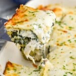 Overhead photo of spatula serving a slice of chicken alfredo lasagna from baking dish. - 9