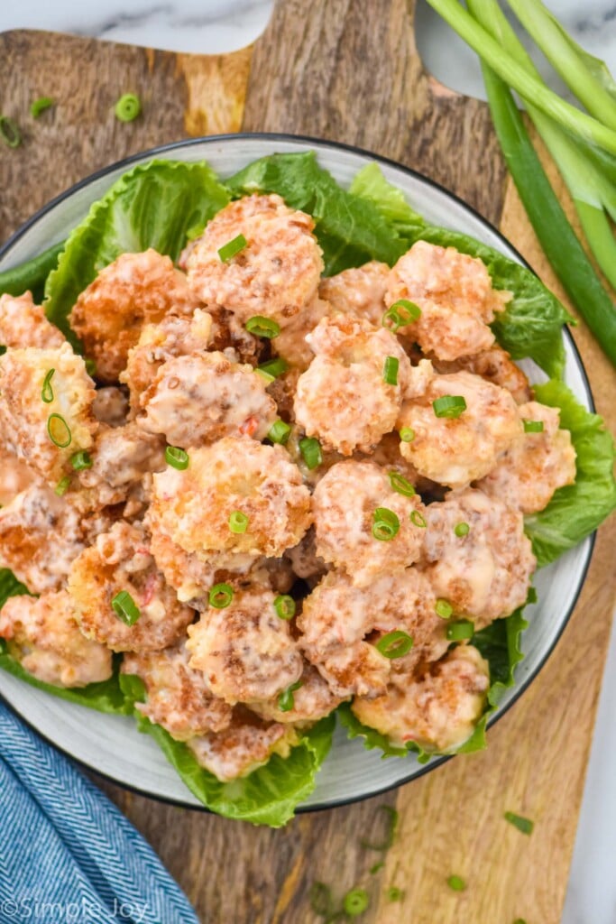 Overhead photo of bang bang shrimp served on a bed of lettuce.