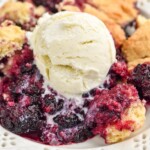 Overhead photo of blackberry cobbler recipe garnished with a scoop of ice cream.
