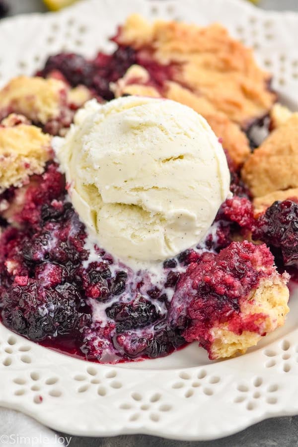 Overhead photo of blackberry cobbler recipe garnished with a scoop of ice cream.