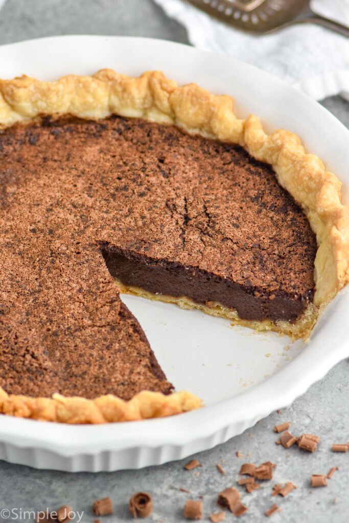 Overhead photo of chocolate chess pie with one slice taken out of the pie dish.