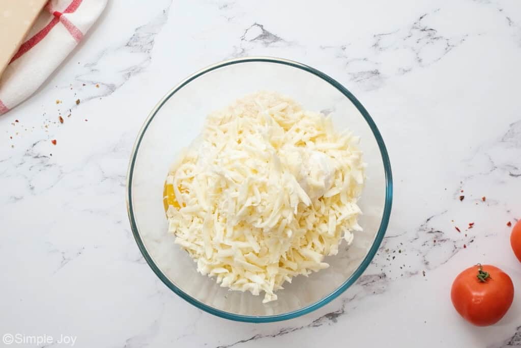 overhead of a bowl of cheeses and filling for crockpot lasagna