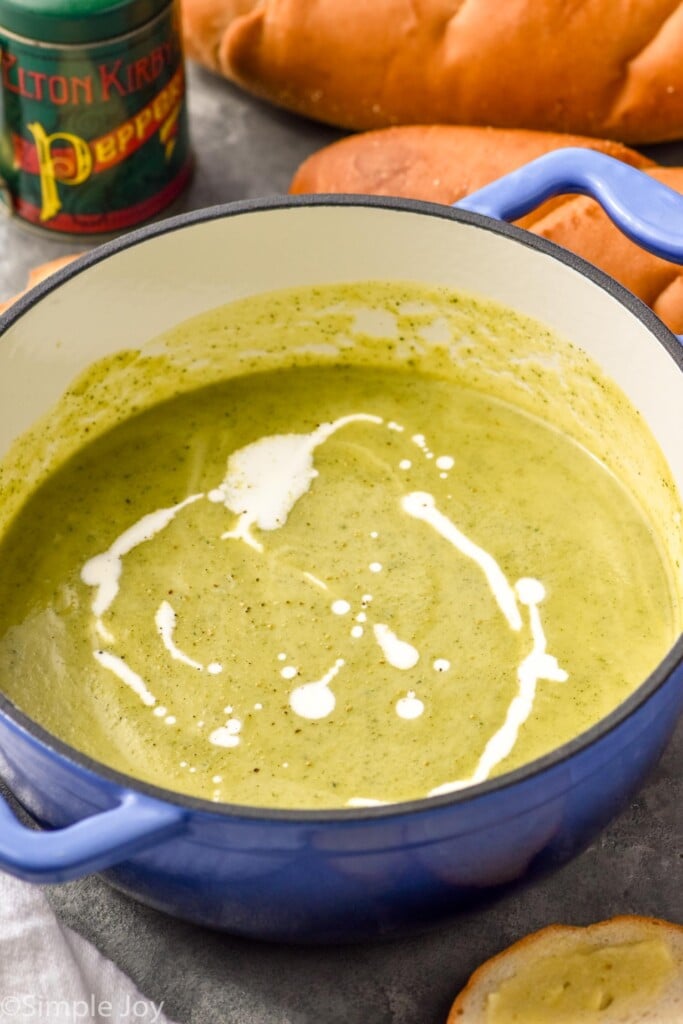 Overhead photo of pot of zucchini soup garnished with cream.
