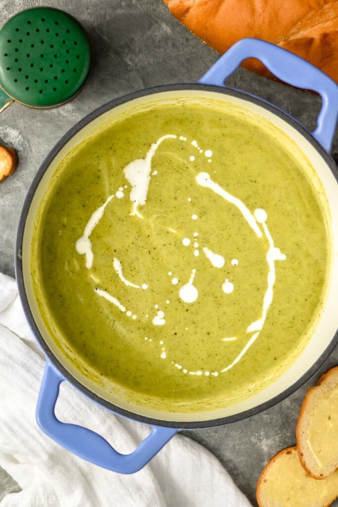 Overhead photo of pot of zucchini soup garnished with cream.
