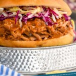 Pinterest graphic of Dr. Pepper Pulled Pork recipe. Image is photo of Dr. Pepper Pulled Pork sandwich garnished with slaw. Text says, "Crock Pot Dr. Pepper Pork simplejoy.com"