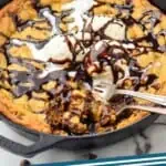 Pinterest graphic for Pizookie recipe. Image is overhead photo of Pizookie recipe garnished with ice cream and hot fudge sauce. Two forks are in the pizookie for eating. Text says, "The Best Pizookie simplejoy.com"