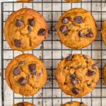 Pinterest graphic for Pumpkin Chocolate Chip Muffins recipe. Text says, "Pumpkin Chocolate Chip Muffins simplejoy.com." Overhead photo of Pumpkin Chocolate Chip Muffins on a cooling rack.