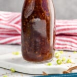 Pinterest graphic of Teriyaki Sauce recipe. Photo of glass bottle of Teriyaki Sauce. Text says, "Homemade Teriyaki Sauce simplejoy.com."