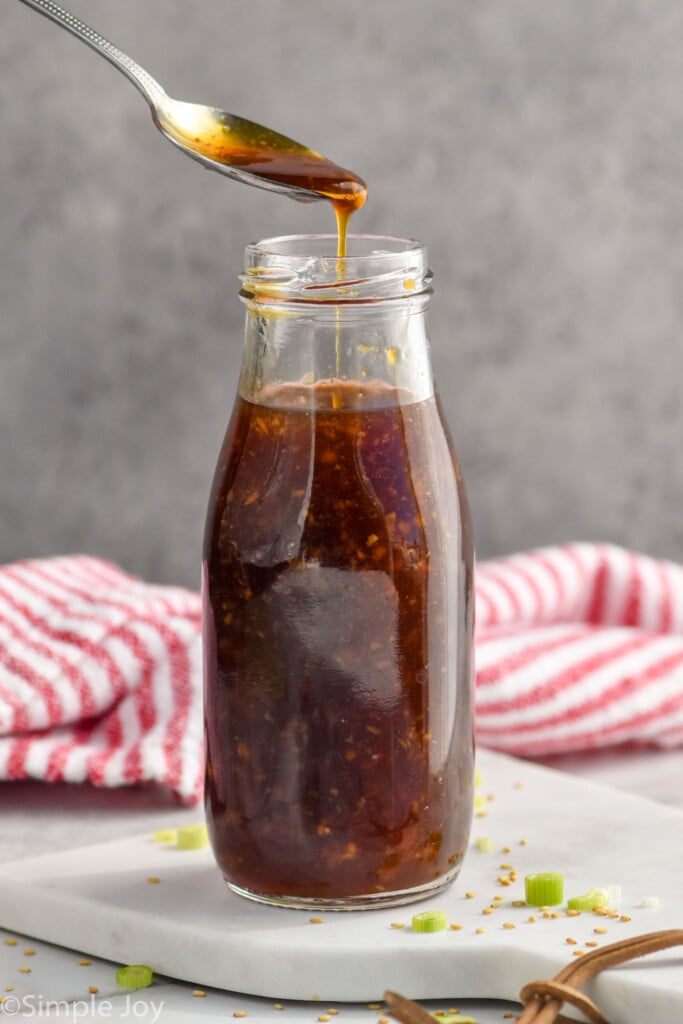 Photo of glass bottle of Teriyaki Sauce with a metal spoon scooping out some of the sauce.