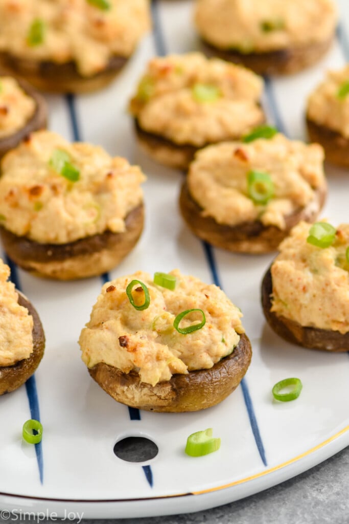 Overhead photo of Crab Stuffed Mushrooms recipe garnished with green onions.