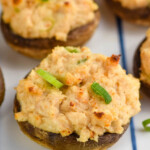 Overhead photo of Crab Stuffed Mushrooms recipe garnished with green onions.