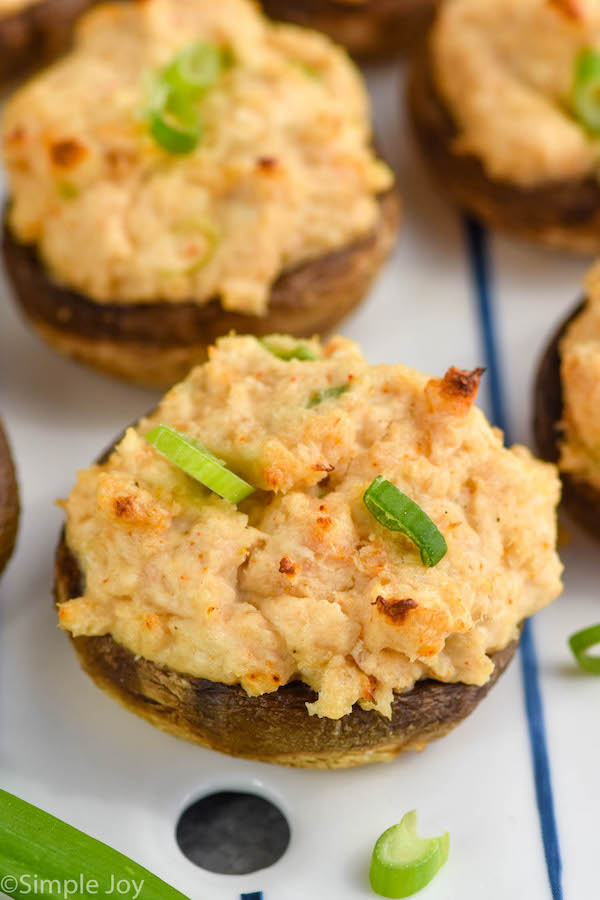 Overhead photo of Crab Stuffed Mushrooms recipe garnished with green onions.