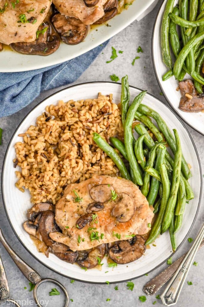 Overhead photo of crock pot pork chops recipe served on a plate with green beans and rice.