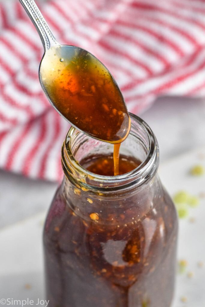 Photo of glass bottle of Teriyaki Sauce with a metal spoon scooping out some of the sauce.