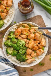 Overhead photo of teriyaki chicken bowl served with broccoli over rice and two forks for eating.