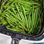 Pinterest graphic for Air Fryer Green Beans recipe. Overhead photo of Air Fryer Green Beans in an air fryer basket. Text says, "Air Fryer Green Beans simplejoy.com"