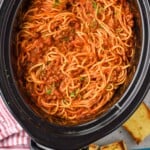 Pinterest graphic of cock pot spaghetti recipe. Overhead photo of Crock Pot Spaghetti recipe in a crock pot. Text says, "Crockpot spaghetti simplejoy.com."