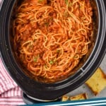 Pinterest graphic of cock pot spaghetti recipe. Overhead photo of Crock Pot Spaghetti recipe in a crock pot. Text says, "Crockpot spaghetti simplejoy.com."