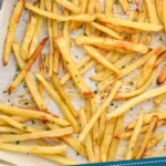 Pinterest graphic for Easy French Fries recipe. Image is overhead photo of Easy French Fries on a baking sheet with a dish of ketchup for dipping. Text says, "Homemade french fries simplejoy.com"