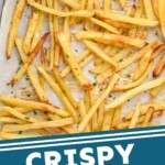 Pinterest graphic for Easy French Fries recipe. Image is overhead photo of Easy French Fries on a baking sheet with a dish of ketchup for dipping. Text says, "Crispy Baked Fries simplejoy.com"