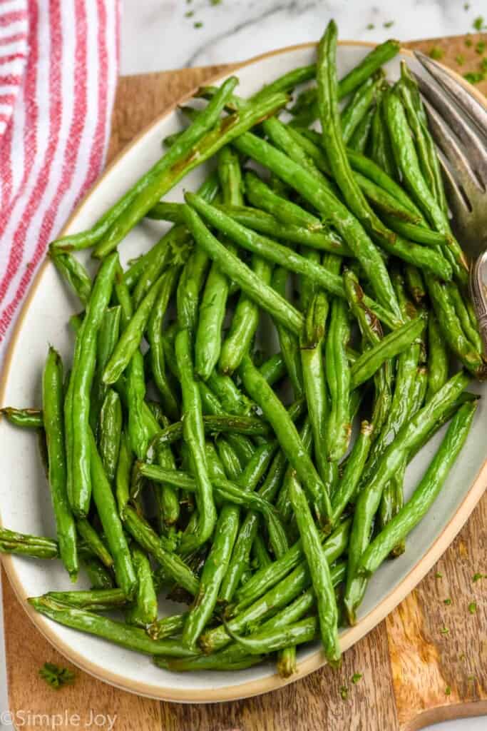 Overhead photo of Air Fryer Green Beans on a serving platter with forks for serving.