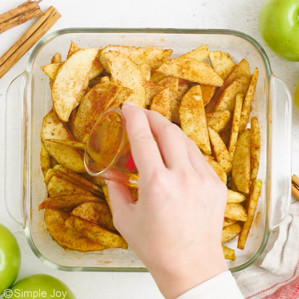 overhead of apple juice being poured over cut apples tossed in cinnamon