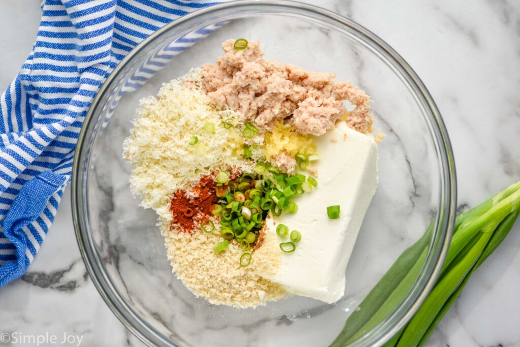 Overhead photo of ingredients for Crab Stuffed Mushrooms in a glass mixing bowl.