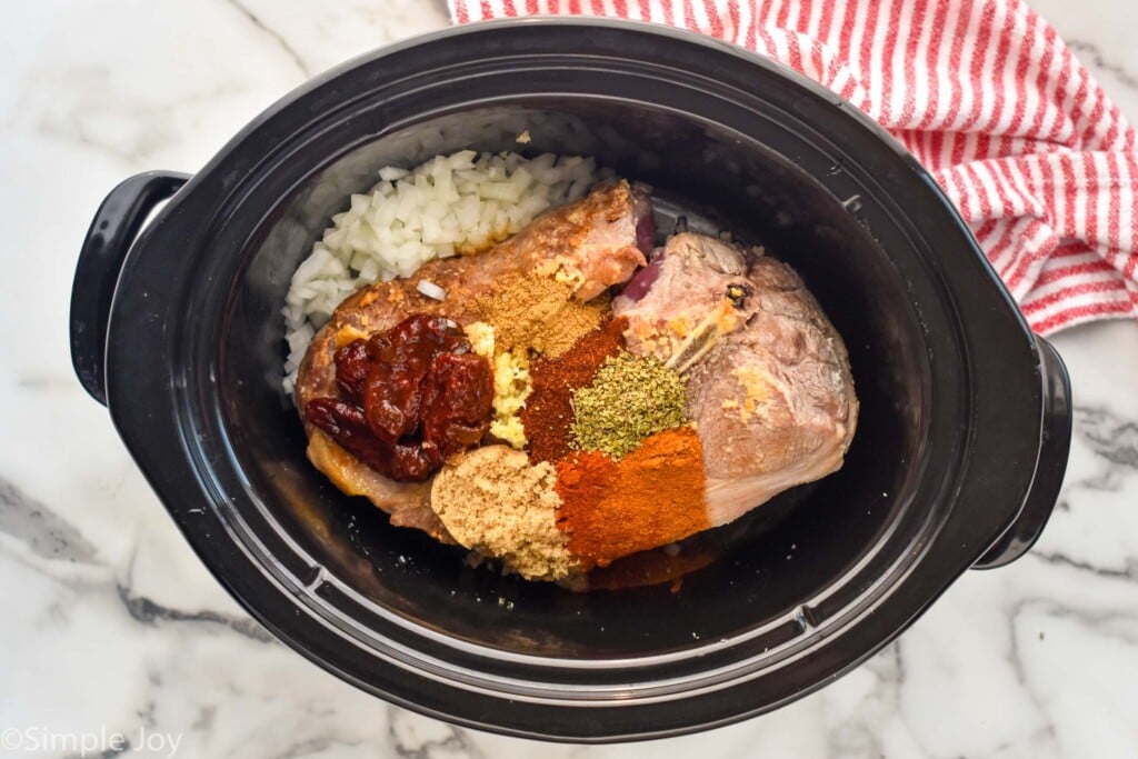 Overhead photo of crockpot with ingredients for pulled pork tacos.