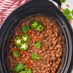 pinterest graphic overhead of pinto beans in a the crock pot after cooking, says: slow cooker pinto beans recipe, simplejoy.com"