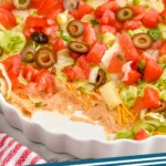 Pinterest graphic for Taco Dip recipe. Image is overhead photo of Taco Dip. Text says, "The best Taco Dip simplejoy.com."