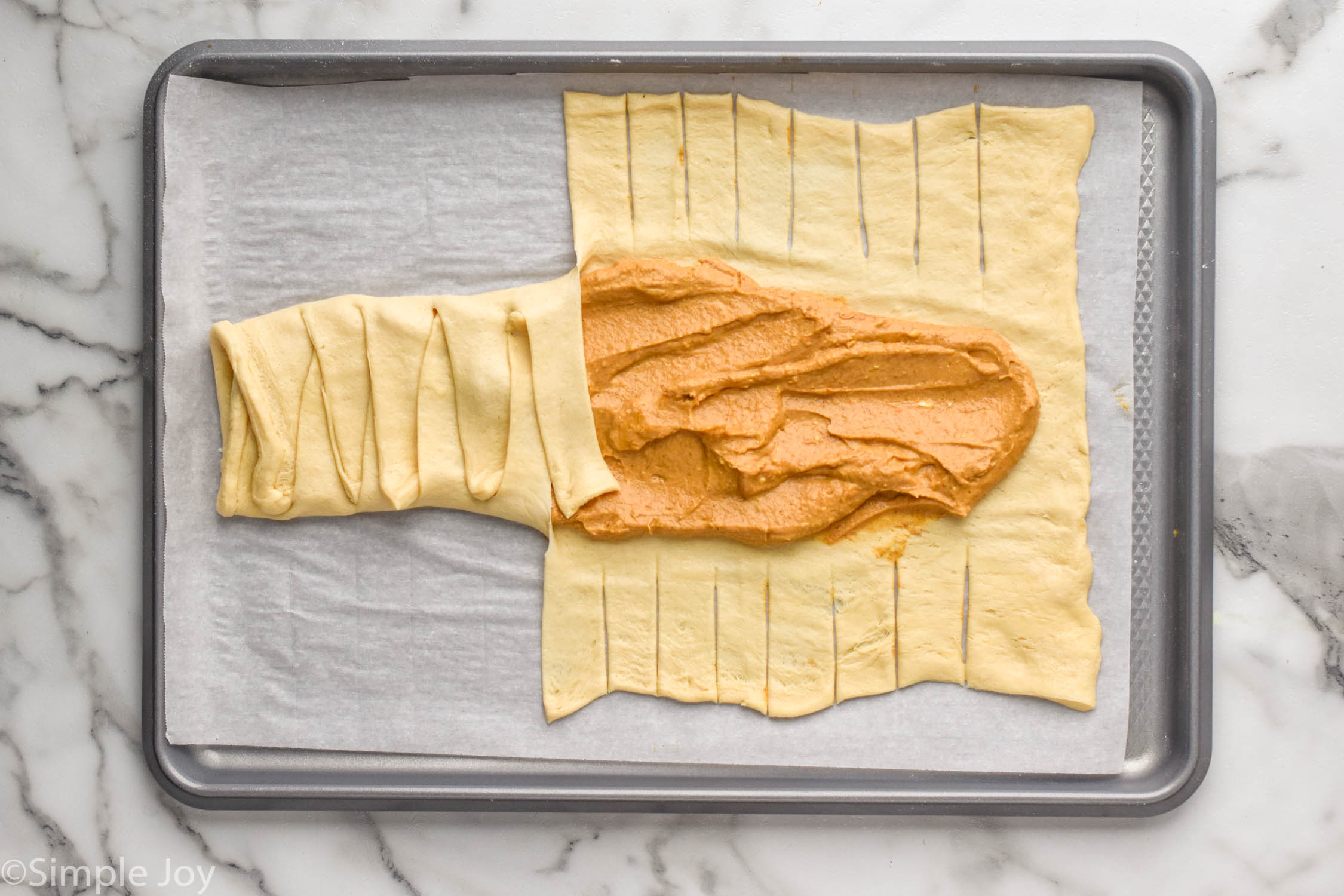 Overhead photo of Pumpkin Cheesecake Braid on a baking sheet preparing for baking.