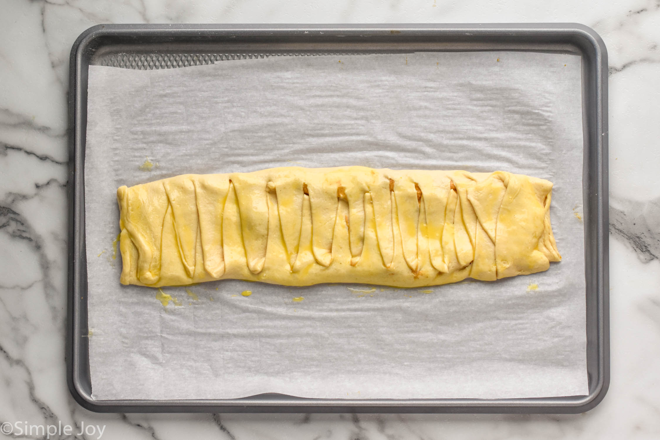 Overhead photo of Pumpkin Cheesecake Braid on a baking sheet ready to be baked.