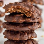 Photo of a stack of No Bake Chocolate Oatmeal Cookies with a bite out of the top cookie.
