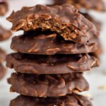 Photo of a stack of No Bake Chocolate Oatmeal Cookies with a bite taken out of the top cookie.