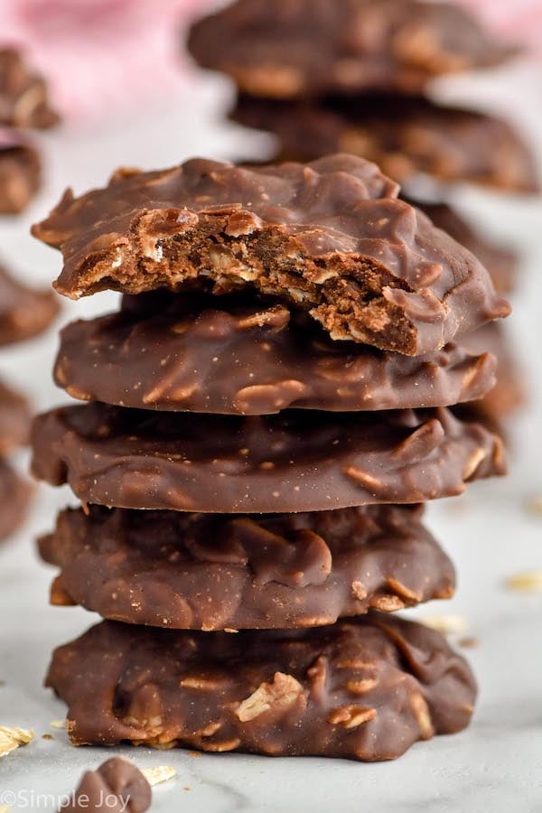 Photo of a stack of No Bake Chocolate Oatmeal Cookies with a bite taken out of the top cookie.