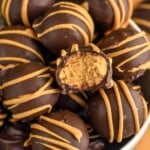 Overhead photo of Peanut Butter Balls in a bowl. One Peanut Butter Ball has a bite taken out. - 9