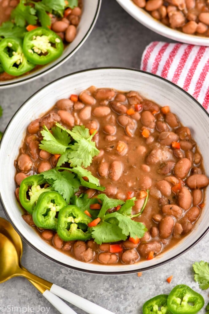 a bowl of pinto beans crock pot recipe garnished with jalapeños and cilantro