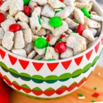 pinterest graphic for Christmas Puppy Chow. Image shows bowl of Christmas puppy chow. Text says "Christmas puppy chow simplejoy.com"