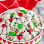 pinterest graphic for Christmas Puppy Chow. Image shows bowl of Christmas puppy chow. Text says "amazing Christmas puppy chow simplejoy.com"