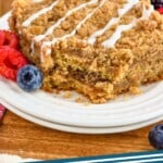 Pinterest image for coffee cake. Image shows a piece of coffee cake with fresh berries on a plate. Text says "Coffee cake simplejoy.com"