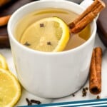 Pinterest graphic of Overhead photo of a Hot Toddy in a white mug with a cinnamon stick and lemon slice in the mug and around the mug, says Super Easy Hot Toddy Recipe simplejoy.com