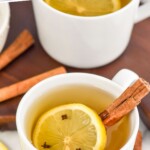 Pinterest graphic of an overhead photo of a Hot Toddy in a white mug with a cinnamon stick and lemon slice in the mug and around the mug, says The Best Hot Toddy Recipe